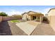 Landscaped backyard featuring a covered patio, gravel, artificial grass, and concrete pavers at 11829 W Rosewood Dr, El Mirage, AZ 85335