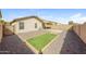 Gravel backyard with an artificial turf area, block wall, and covered patio at 11829 W Rosewood Dr, El Mirage, AZ 85335