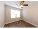 Bedroom with wood-look flooring, ceiling fan, and a window at 11829 W Rosewood Dr, El Mirage, AZ 85335