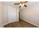 This bedroom features a ceiling fan and a closet with white sliding doors at 11829 W Rosewood Dr, El Mirage, AZ 85335