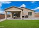 A backyard with artificial grass, covered patio, and sliding glass doors creating a seamless indoor-outdoor living at 1211 E Jahns Dr, Casa Grande, AZ 85122