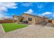 Private backyard featuring artificial turf, a covered patio, rock landscaping, and a tan stucco exterior at 1211 E Jahns Dr, Casa Grande, AZ 85122