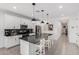 Modern kitchen with sleek white cabinets, a large island with seating, and stainless steel appliances at 1211 E Jahns Dr, Casa Grande, AZ 85122