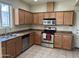 Well-lit kitchen with stainless steel appliances, wooden cabinets, and tile flooring at 1225 N 36Th St # 1054, Phoenix, AZ 85008