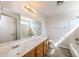 The bathroom offers neutral walls, plank floors, an expansive mirror and a white countertop and vanity at 12325 W Charter Oak Rd, El Mirage, AZ 85335