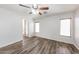 This bedroom boasts a ceiling fan, plank floors, white walls, baseboards and two bright, shuttered windows at 12325 W Charter Oak Rd, El Mirage, AZ 85335