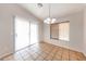 Bright dining area with sliding glass door, tile floors, and stylish chandelier lighting at 12325 W Charter Oak Rd, El Mirage, AZ 85335