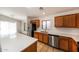 Well-lit kitchen features stainless steel appliances, wood cabinets, quartz countertops, and tile floors at 12325 W Charter Oak Rd, El Mirage, AZ 85335