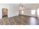 Open living room with wood floors, ceiling fan, and lots of natural light from multiple windows at 12325 W Charter Oak Rd, El Mirage, AZ 85335