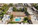 Aerial view of community pool, tennis court, and surrounding buildings and greenery under clear skies at 1328 S Mckemy St, Tempe, AZ 85281