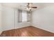 Bright bedroom features hardwood floors, a ceiling fan, and window with sheer and gray curtains at 1328 S Mckemy St, Tempe, AZ 85281