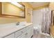 Well-lit bathroom featuring a vanity with white cabinets, a tub with shower, and a large mirror at 1333 E Rockledge Rd, Phoenix, AZ 85048