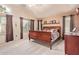 Well-lit main bedroom with a wooden sleigh bed, carpeting, and dual windows with views at 1333 E Rockledge Rd, Phoenix, AZ 85048