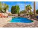 Stunning pool area with rock features and lush landscaping offers a tranquil escape in the backyard at 1333 E Rockledge Rd, Phoenix, AZ 85048