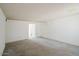 Spacious living room featuring neutral walls, carpet flooring, and a doorway to an adjacent room at 13425 N 16Th Ave, Phoenix, AZ 85029