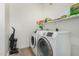 Functional laundry room with modern washer and dryer, storage shelf, and cleaning tools at 13700 N Fountain Hills Blvd # 327, Fountain Hills, AZ 85268