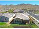 An aerial view of a home showcasing its backyard, neighborhood, and the scenic mountain backdrop at 16788 W Beth Dr, Goodyear, AZ 85338