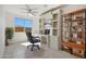 Well-lit home office with a ceiling fan, built-in shelving, and a view of the outdoors at 16788 W Beth Dr, Goodyear, AZ 85338