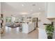 An open kitchen showcases an island with seating and stainless steel appliances adjacent to the living area at 16788 W Beth Dr, Goodyear, AZ 85338