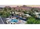 Aerial view of a neighborhood showcasing desert landscaping, community pool, mountains in the distance, and palm trees at 1803 E Hayward Ave # 1, Phoenix, AZ 85020