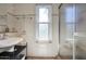 Bright bathroom featuring a pedestal sink and a glass-enclosed shower, all accentuated with elegant tiled walls at 1803 E Hayward Ave # 1, Phoenix, AZ 85020