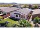 An aerial view of a backyard with artificial turf, covered patio, desert plants and a fenced perimeter at 18430 E Azul Ct, Gold Canyon, AZ 85118