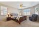 Relaxing bedroom with a cozy recliner, ceiling fan, and a beautiful wood-framed bed at 18430 E Azul Ct, Gold Canyon, AZ 85118