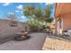 Beautiful backyard brick patio featuring a water fountain, seating area, and mature landscaping at 20148 N Big Dipper Dr, Maricopa, AZ 85138