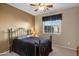 Bedroom showcasing a wrought iron bed frame, neutral walls, and bright window at 20148 N Big Dipper Dr, Maricopa, AZ 85138