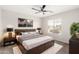 Well-lit bedroom featuring a wood-frame bed, neutral decor, and a soft rug for a cozy and calming atmosphere at 2023 S 106Th Ave, Tolleson, AZ 85353