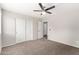 Comfortable bedroom featuring neutral carpet, a ceiling fan, and sliding closet doors for convenient storage at 2023 S 106Th Ave, Tolleson, AZ 85353