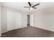 Cozy bedroom with neutral carpet, ceiling fan, and sliding closet doors for ample storage solutions at 2023 S 106Th Ave, Tolleson, AZ 85353