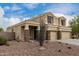 Home exterior featuring a three-car garage and desert rock landscaping at 2023 S 106Th Ave, Tolleson, AZ 85353