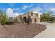 Exterior view of a two-story home with a three-car garage and front desert landscaping at 2023 S 106Th Ave, Tolleson, AZ 85353