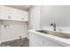 Laundry room featuring white cabinets, stainless steel sink, and tile floors at 2023 S 106Th Ave, Tolleson, AZ 85353