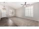 Bright living room with plush carpet, shuttered windows, and contemporary ceiling fan at 2023 S 106Th Ave, Tolleson, AZ 85353