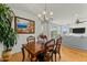 Dining room with a wooden table, chandelier, and views into the living room at 20701 W Minnezona Ave, Buckeye, AZ 85396