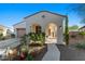 Front exterior featuring an arched entryway, desert landscaping, and a two-car garage at 20701 W Minnezona Ave, Buckeye, AZ 85396