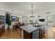 Kitchen island with granite countertop and stainless steel appliances, open to the dining and living areas at 20701 W Minnezona Ave, Buckeye, AZ 85396