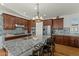 Kitchen featuring dark wood cabinets, stainless steel appliances, and granite countertops at 20701 W Minnezona Ave, Buckeye, AZ 85396