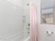 Shower and tub combo featuring white tile and neutral walls in this bathroom at 21295 E Estrella Rd, Queen Creek, AZ 85142