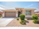 Charming single-story home with a stone facade, well-manicured landscaping, and a two-car garage at 21295 E Estrella Rd, Queen Creek, AZ 85142