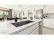 Spacious kitchen island with stainless steel sink, modern faucet, and stainless steel refrigerator in background at 21295 E Estrella Rd, Queen Creek, AZ 85142