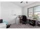 Bright home office with a large window, built-in desk and a gray accent wall at 21295 E Estrella Rd, Queen Creek, AZ 85142