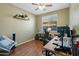 Cozy bedroom featuring hardwood floors, natural light, and a comfortable desk area at 2340 S 238Th Ln, Buckeye, AZ 85326