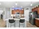 Well-lit kitchen with stainless steel appliances, marble countertops, and dark brown cabinetry at 2340 S 238Th Ln, Buckeye, AZ 85326