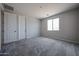 Bright bedroom with gray carpet, two doors, and a window providing natural light at 2570 E Music Mountain Ave, Apache Junction, AZ 85119