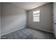 A simple bedroom with a window for natural light and neutral colored walls and carpet at 2570 E Music Mountain Ave, Apache Junction, AZ 85119