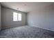 A sunny bedroom with a large window for natural light, neutral colored walls and carpet at 2570 E Music Mountain Ave, Apache Junction, AZ 85119
