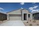 Single-story home showcasing a neutral color palette, xeriscaping, and a two-car garage under a bright blue sky at 2570 E Music Mountain Ave, Apache Junction, AZ 85119